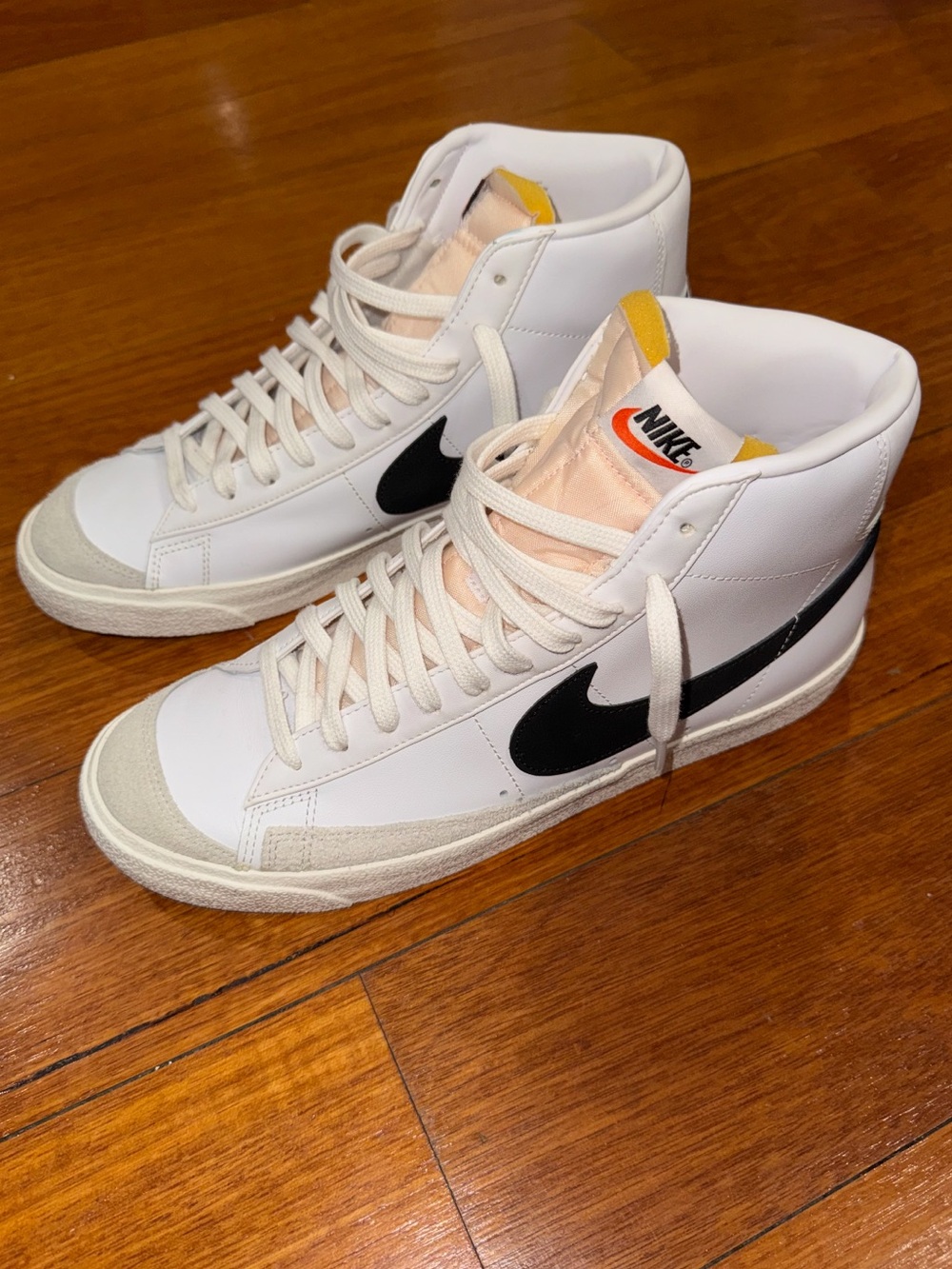 Nike White High-Top Sneakers with Black Swoosh and Yellow Tongue Tab